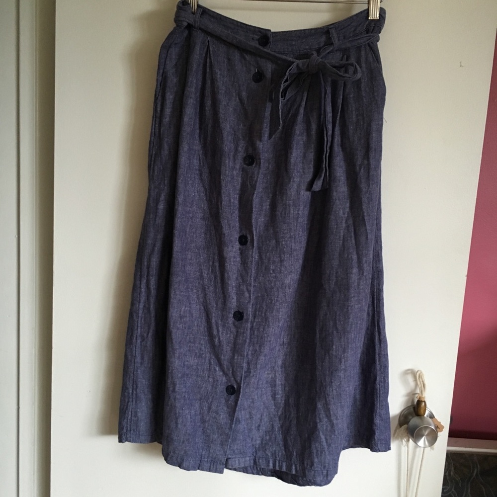 Blue cotton linen skirt with cinch tie, buttons, pockets
30” waist- 41” length